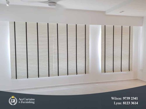 White venetian blinds tilted close in a living room.